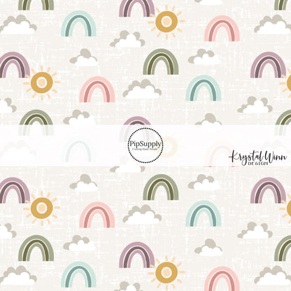 Gray and white clouds with green, blue, pink, and purple rainbows and gold sunshine on a gray distressed bow strip