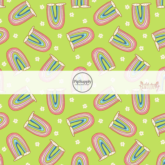 Light green fabric by the yard with white flowers and colorful rainbows