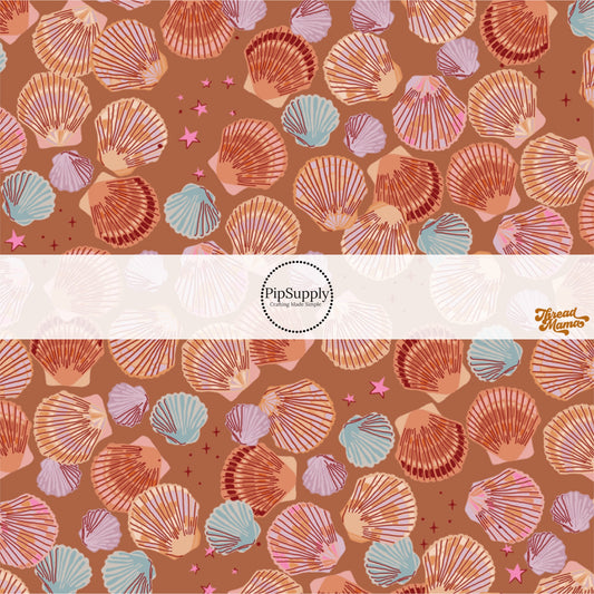 Scattered multi-colored seashells and pink stars on copper fabric by the yard.