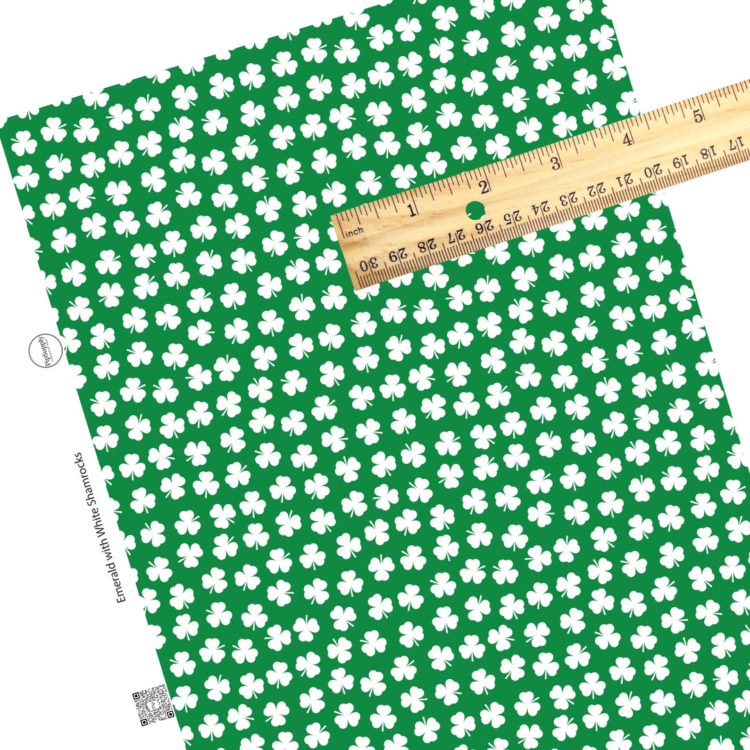 Scattered white clovers on dark green faux leather sheet