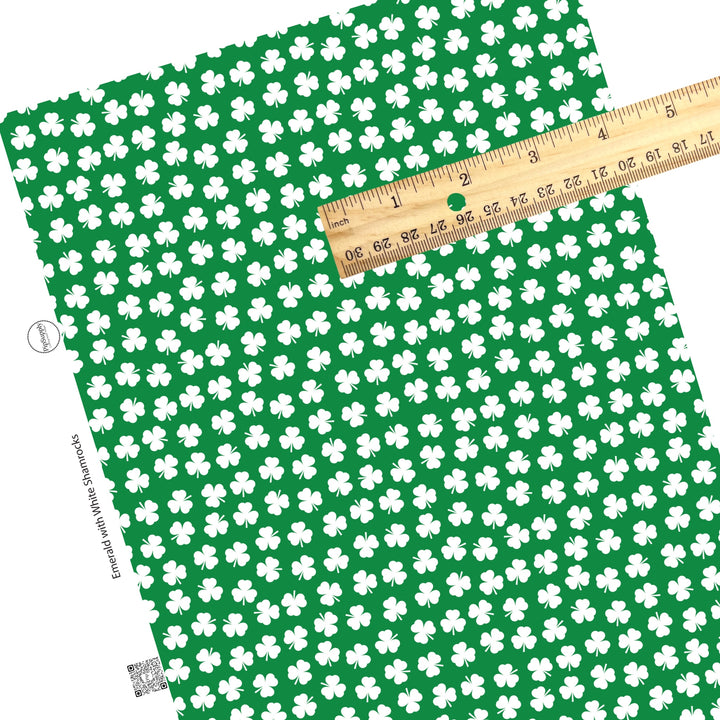 Scattered white clovers on dark green faux leather sheet