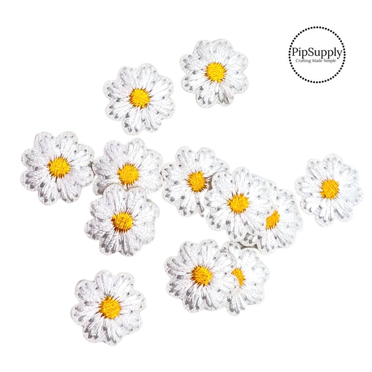 Small round white daisy embroidered flowers with yellow centers 
