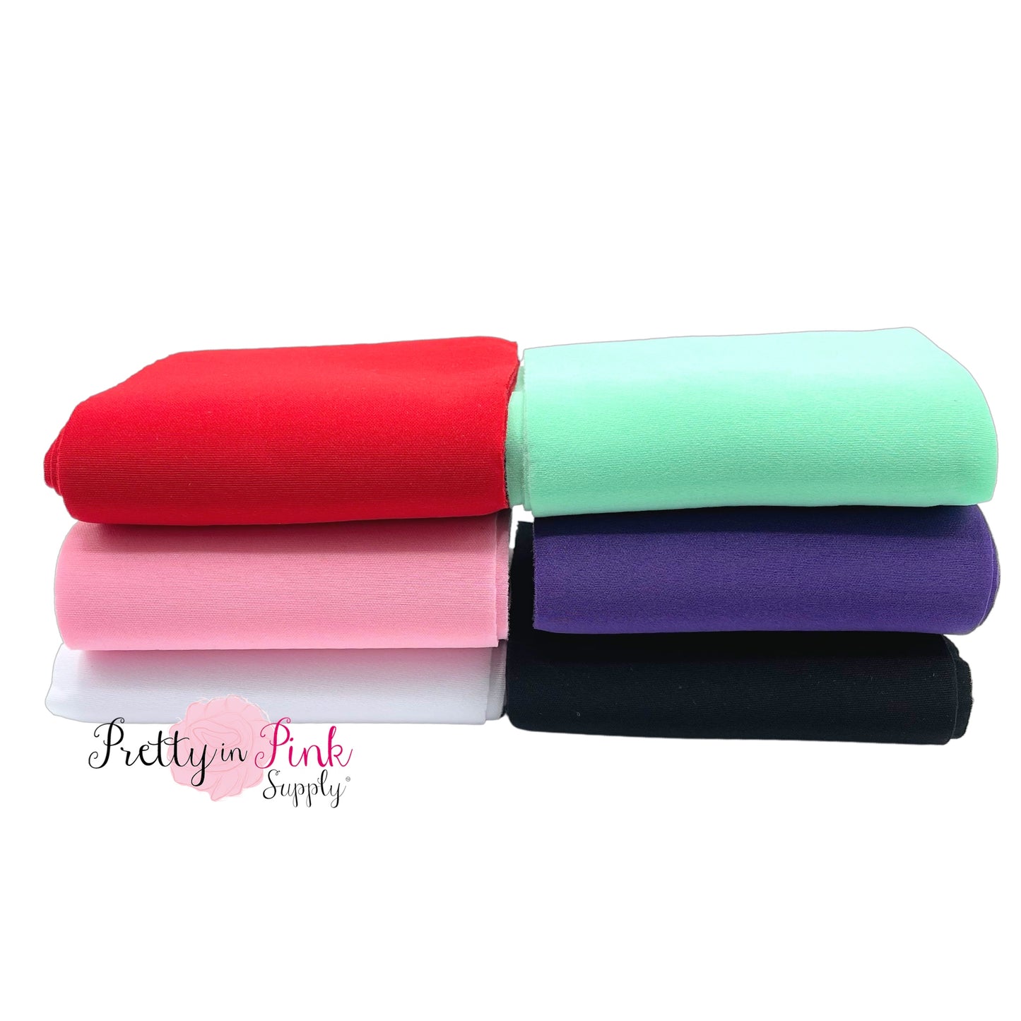 Folded solid colored neoprene fabric in red, light aqua, purple, black, light pink, and white.