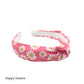 Coral pink fabric knotted headband with white smiling daisy pattern designed by Hey Cute design.