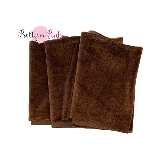 Folded over brown color stretch velvet fabric strip.