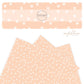 Cream dots on blush faux leather sheet.