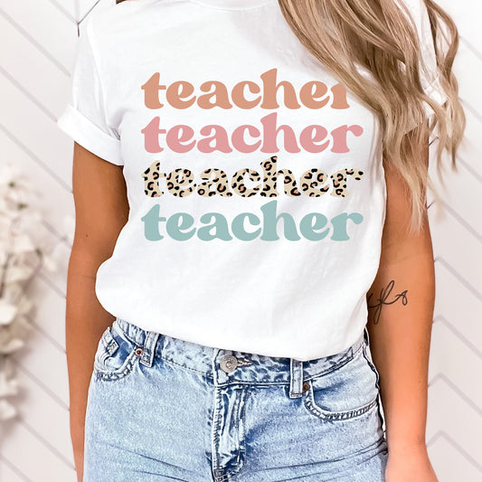 Iron on heat transfer with the word "Teacher" in the colors orange, pink, leopard print, and aqua.