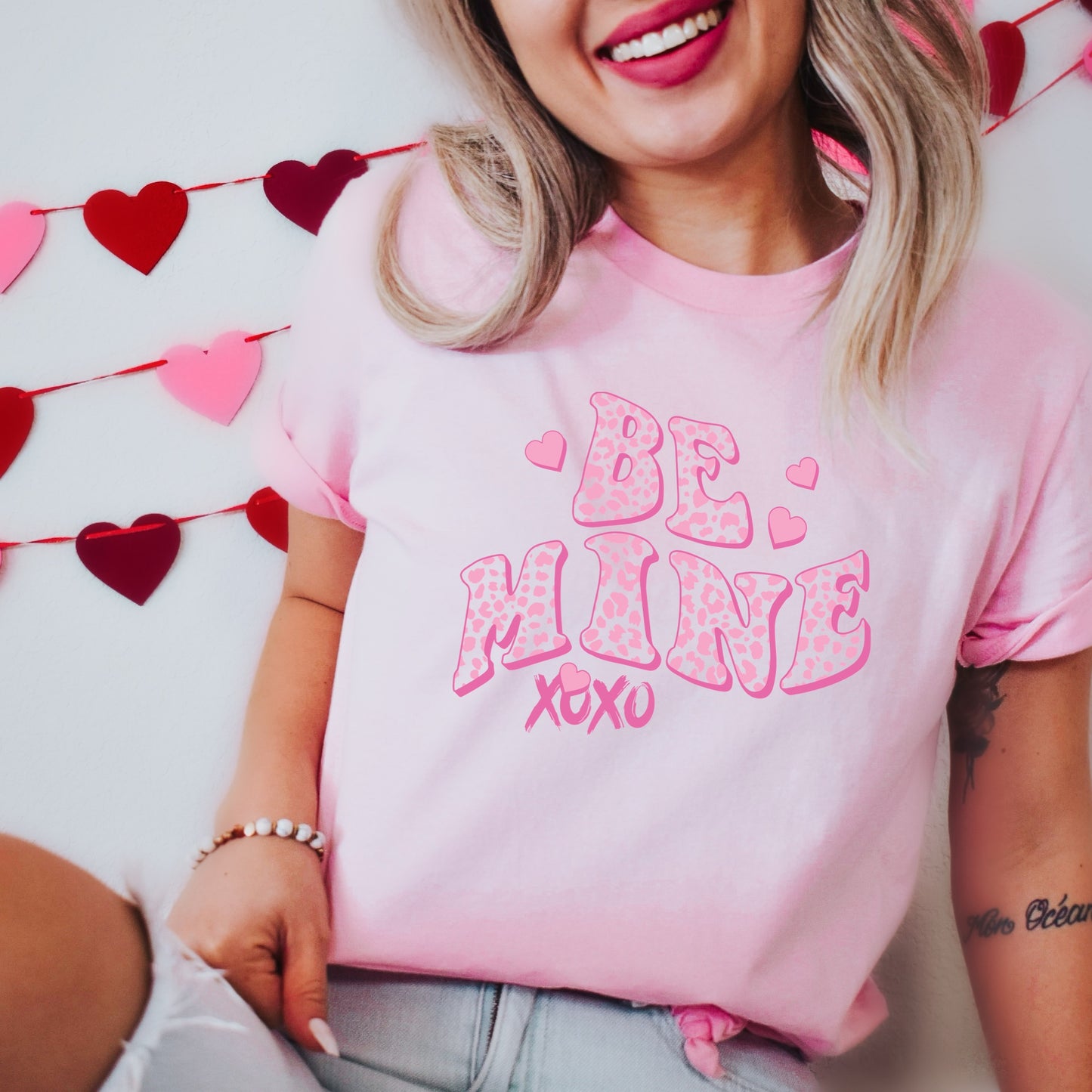 Pink shirt with a graphic iron-on that says "Be Mine XOXO" and a leopard print design heat transfer iron on