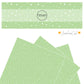 Scattered white polka dots on a mint green faux leather sheet.