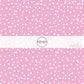 Pink fabric by the yard with scattered small white polka dots.