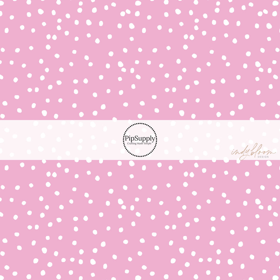 Pink fabric by the yard with scattered small white polka dots.