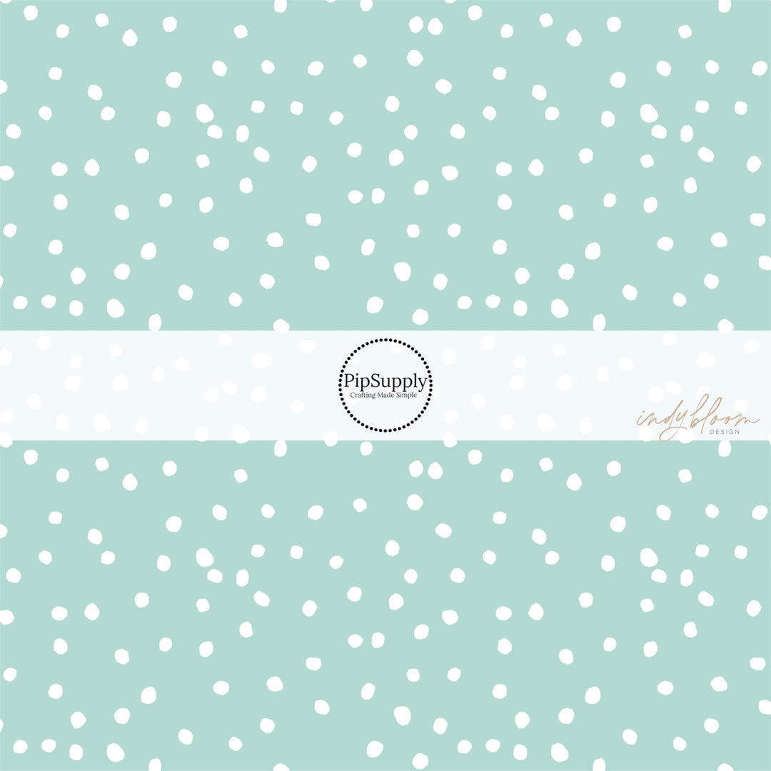 Mint green fabric by the yard with scattered small white polka dots.