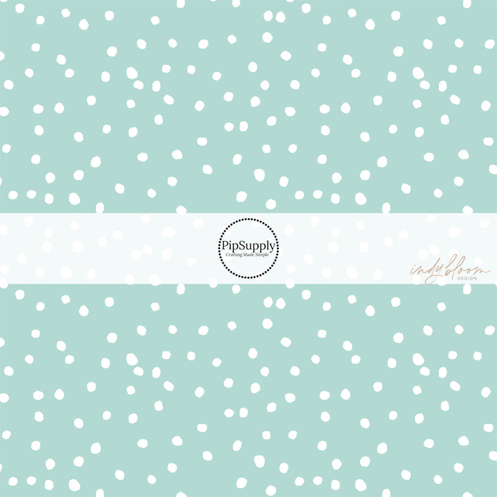 Mint green fabric by the yard with scattered small white polka dots.