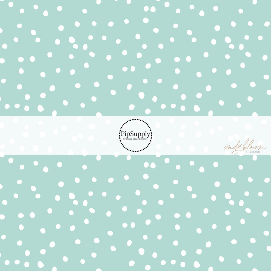 Mint green fabric by the yard with scattered small white polka dots.