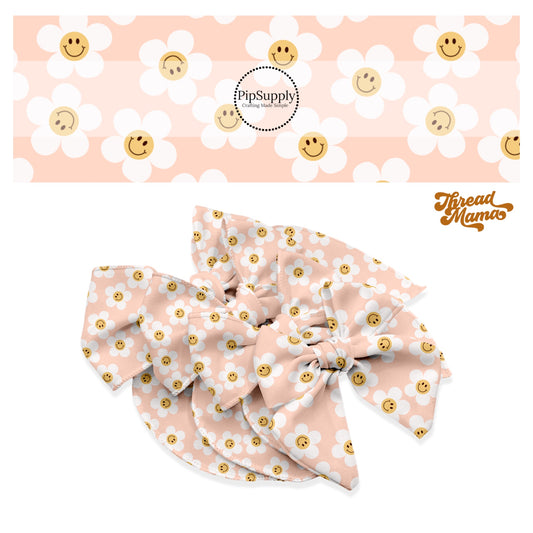 Scattered white daisies with orange smiley faces on pink bow strips
