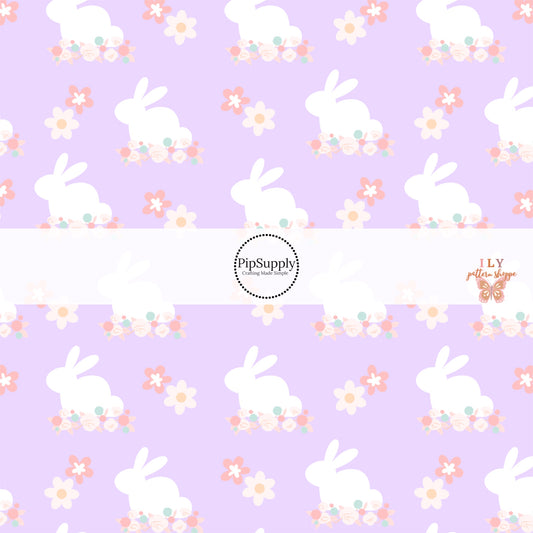 White Easter bunny print with floral designs on purple fabric by the yard.