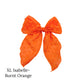 Large Burnt orange colored bow with frayed dots on a white background