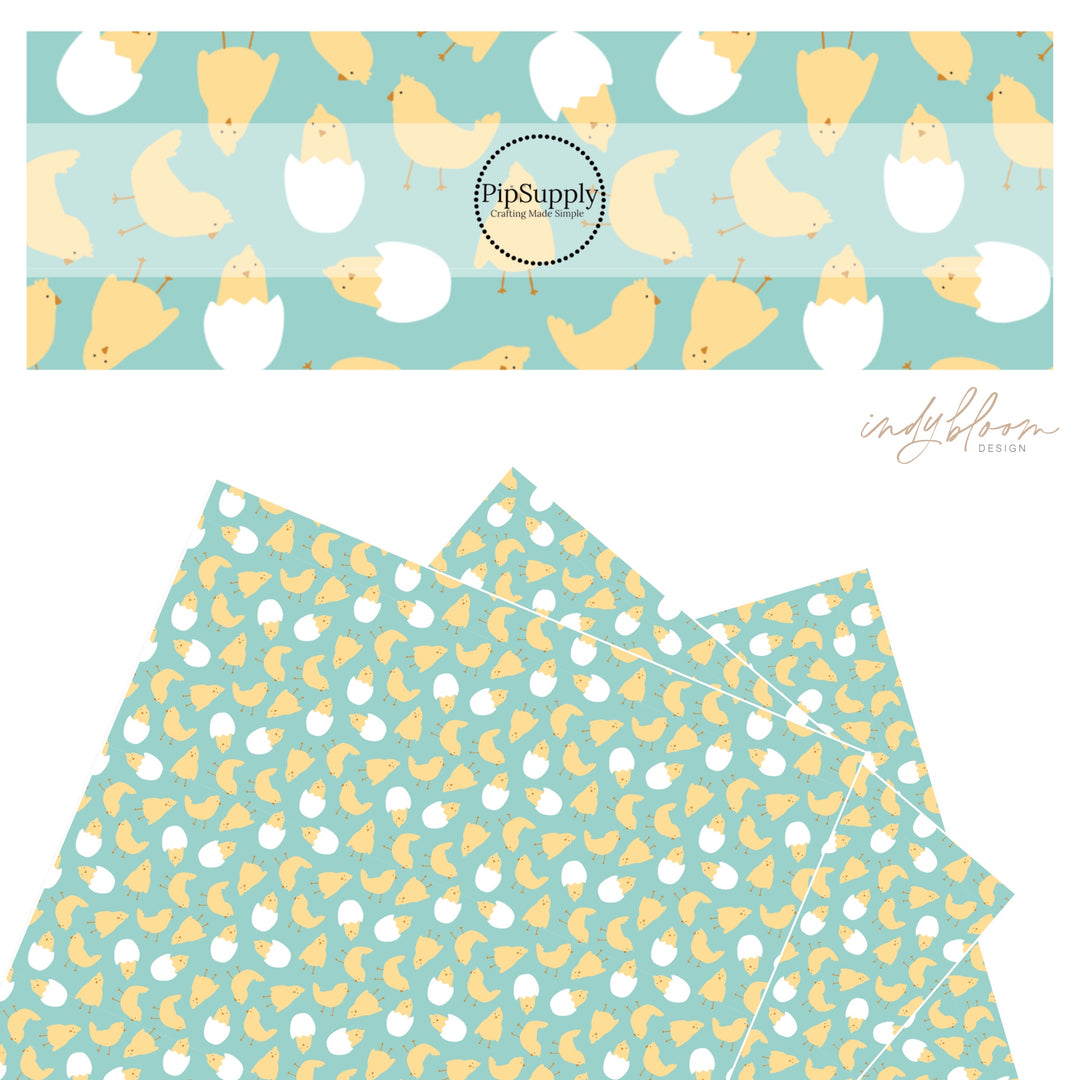 Yellow baby chick hatching in a white egg on teal faux leather sheets