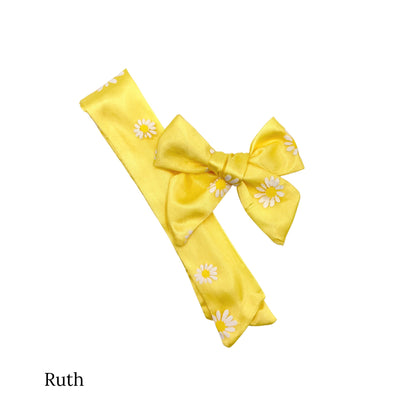 Yellow tulle bow with white daisies with yellow center on a ruth bow strip