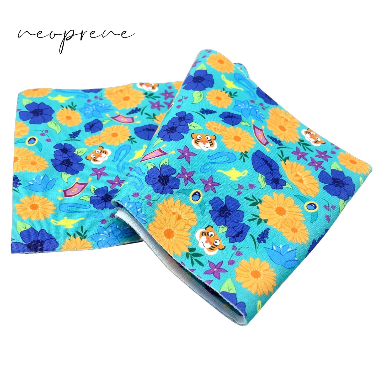 Folded padded aqua neoprene fabric with royal, golden yellow, and purple floral princess pattern including flying carpets, tiger face, and magic lamps.
