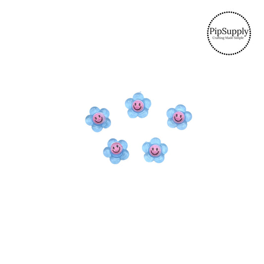 Pink smiley face on blue daisy embellishment