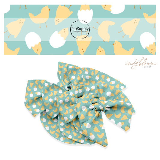 Yellow baby chicks in white cracked eggs on teal bow strips