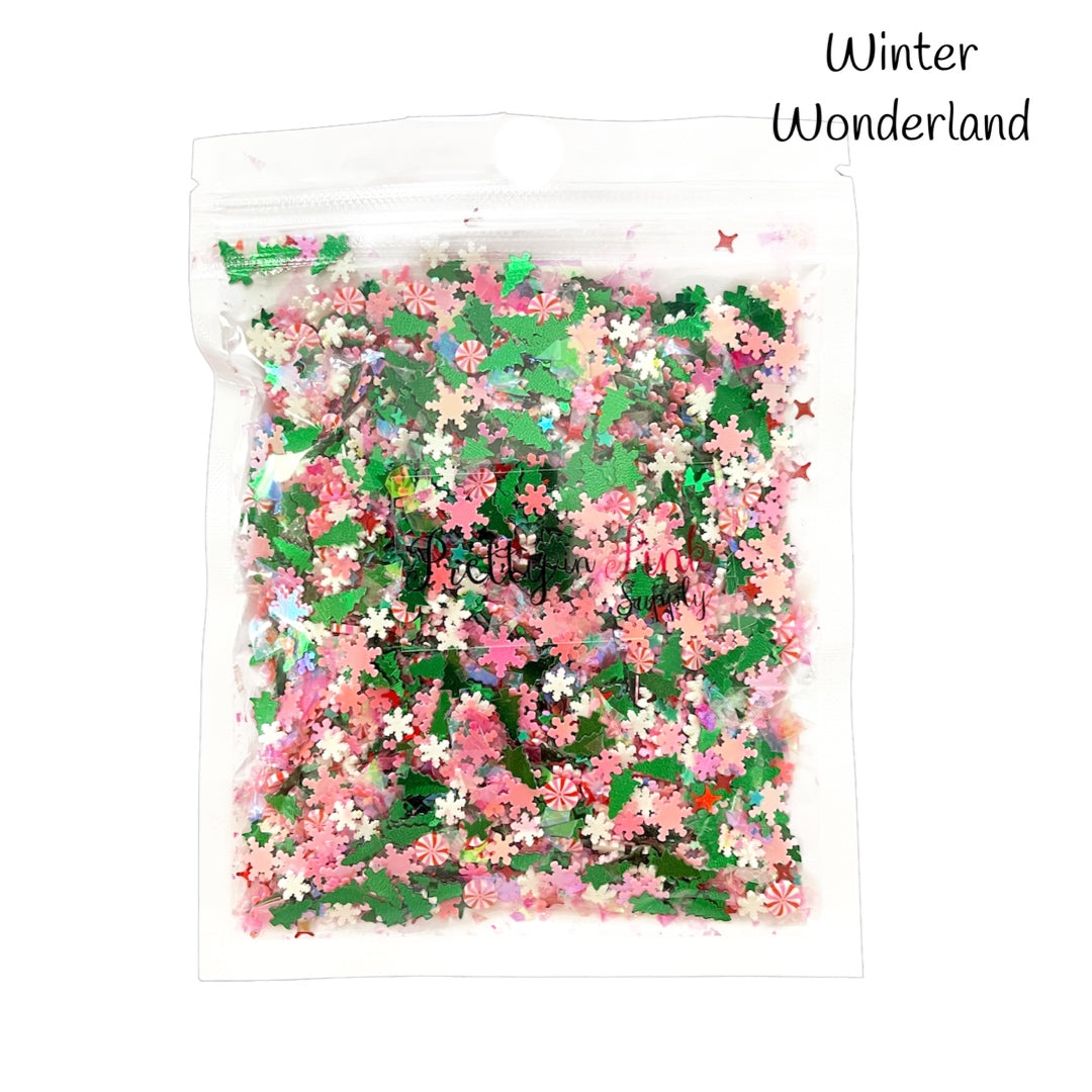 Bag of mixed green Christmas tree sequin glitter, pink snowflake sequin glitter, red sparkle sequin, white snowflake clay slices, and red and pink swirl peppermint polymer clay slices.