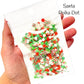 Bag of polymer clay slice mix of red and green polymer clay dots, little Santa faces clays, and peppermint clays.