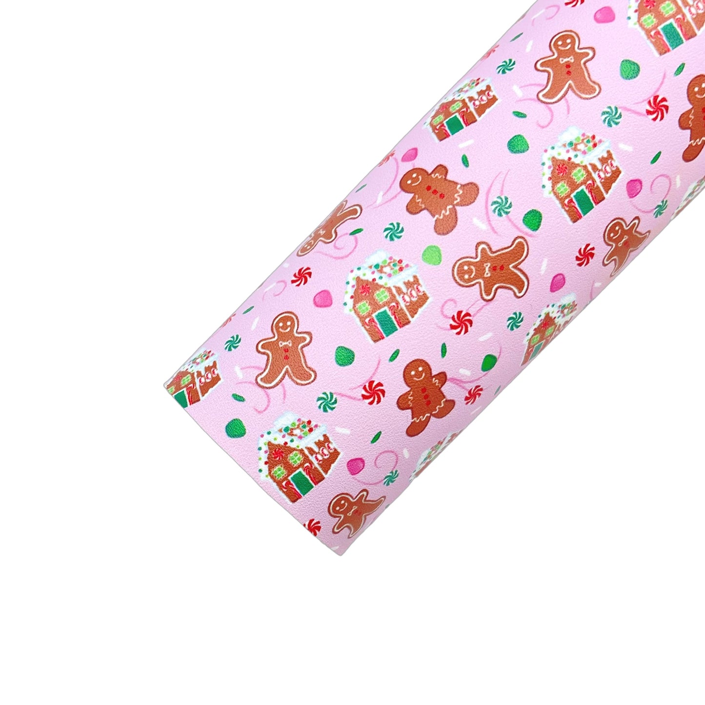 Rolled pink faux leather sheet with gingerbread house, gingerbread man, and gumdrop Christmas pattern.