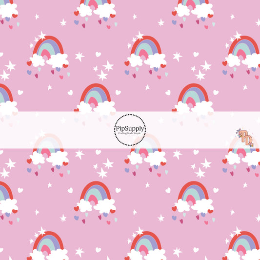 These rainbows, hearts, and stars on pink fabric by the yard features pink, mint, lavender, and red rainbows on white clouds along with tiny stars and multicolor hearts.