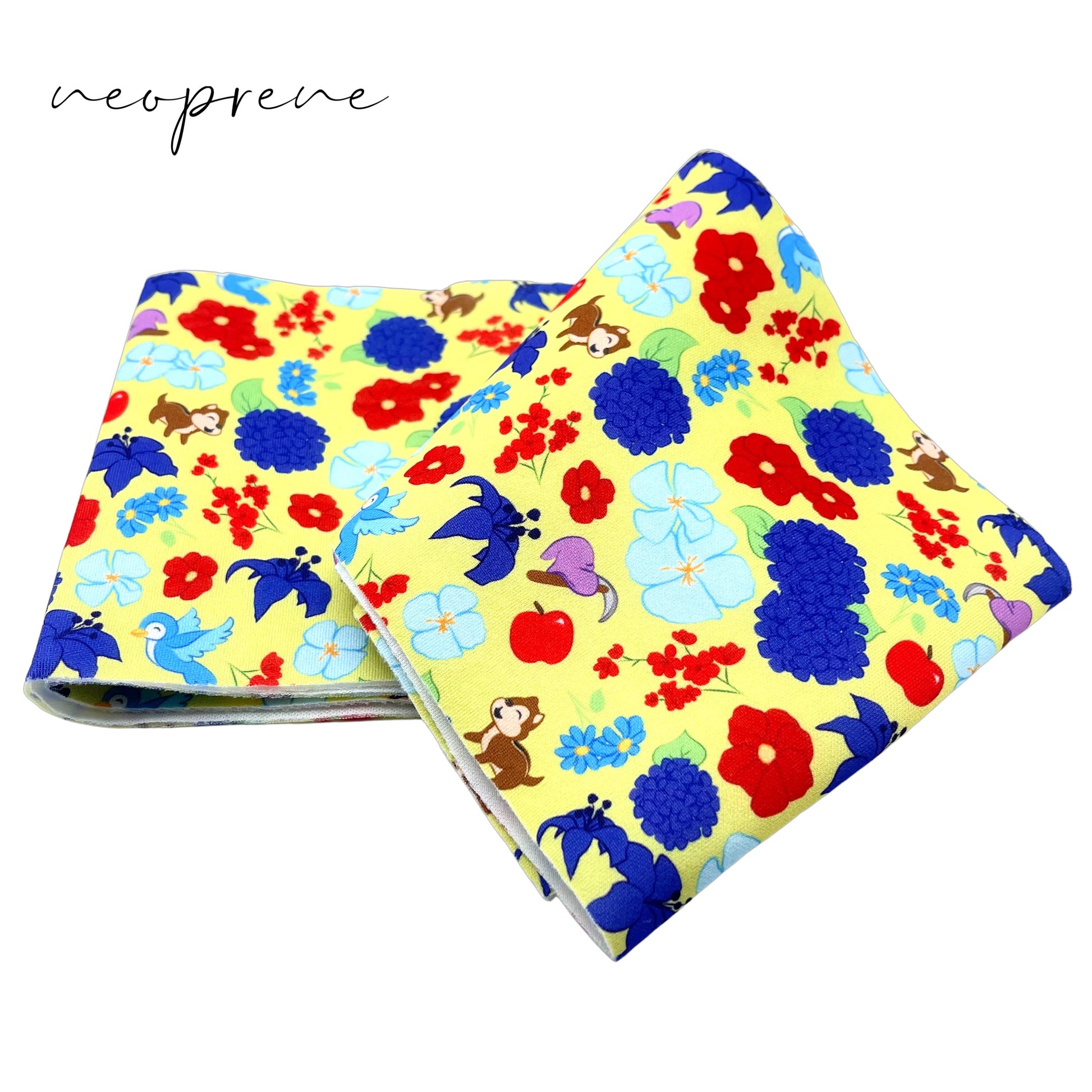 Folded yellow neoprene fabric strip with royal, red, and light blue floral princess pattern including chipmunks, hat and axe, apple, and blue bird.