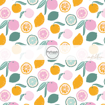 Whole and half pink, green, and orange citrus fruit on white bow strips