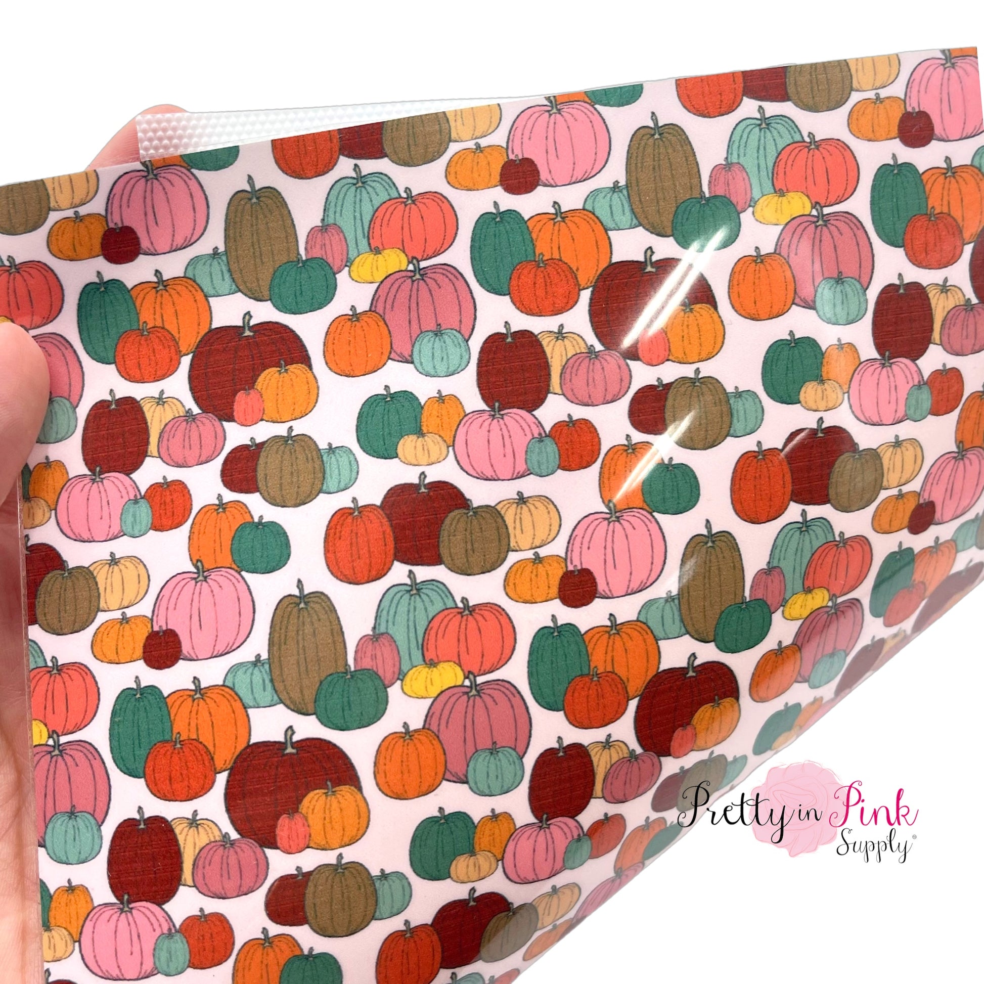 Ivory heat transfer vinyl with pattern of different colored pumpkins.