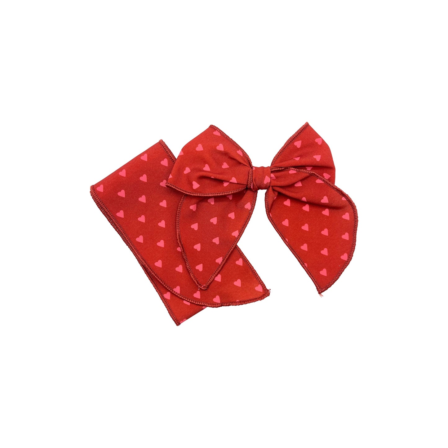 Tied and untied red Isabelle style fabric bow strip with pink heart pattern.