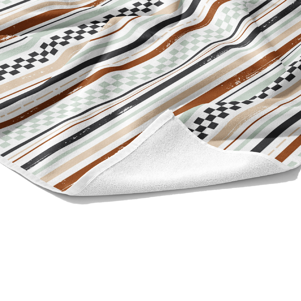 This beach towel is multi colored stripes in light brown, tan, gray, and pistachio. 