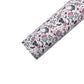 Rolled pale peach pink faux leather sheet wit pink, black and aqua new years party pattern.