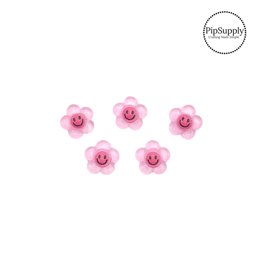 Pink happy faces on pink daisy embellishment