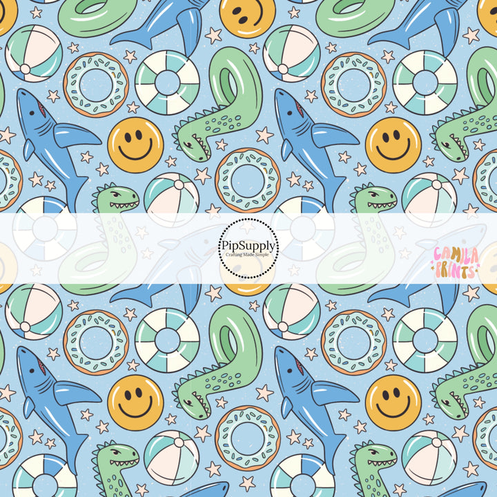 Blue fabric by the yard with dinosaur pool floaties, smiley faces, stars, and sharks.