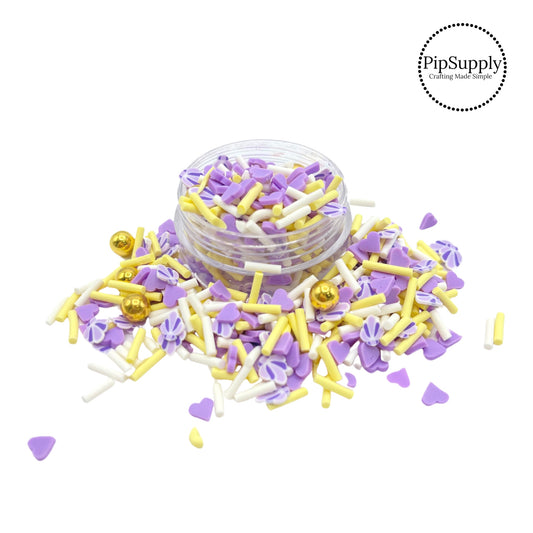Yellow and white sprinkles with gold pearls and purple hearts and seashell clay slices