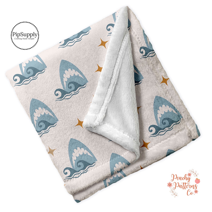 Cream minky blanket custom printed with sharks and waves .