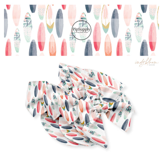 Pink, navy, peach, and floral surfboards on white bow strips