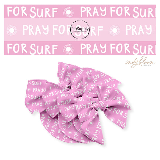 Pray for surf written in white with sunshine on pink bow strips
